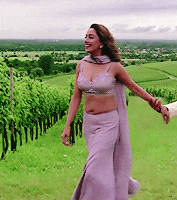 a woman in a purple dress is holding a man 's hand in a grassy field
