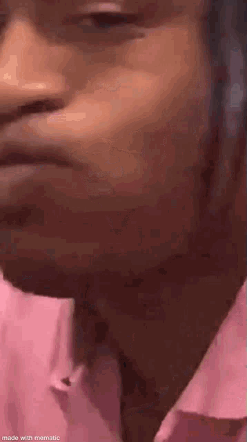 a close up of a person 's face wearing a pink shirt .