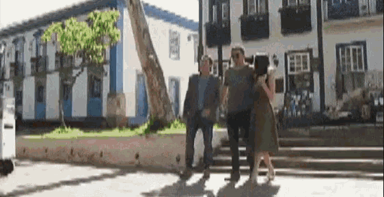 a man and a woman are walking down stairs in front of a building .