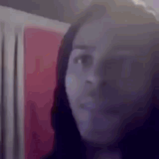 a blurry picture of a woman 's face with a red background