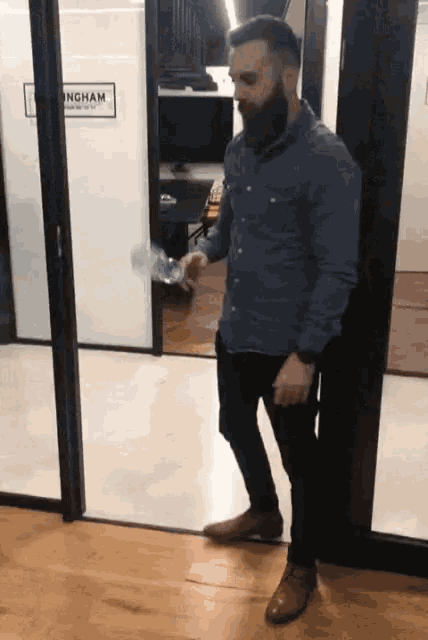 a man with a beard is standing in front of a sign that says ingham