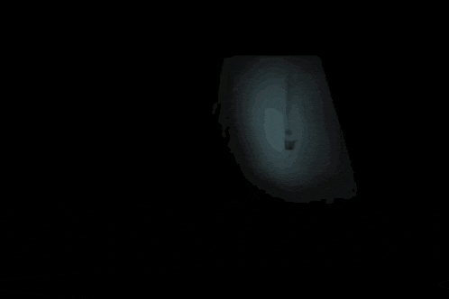 a man with a scary face is standing in the dark and holding something in his hands .