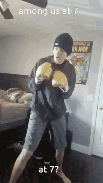 a man wearing boxing gloves is standing in front of a poster that says among us at 7