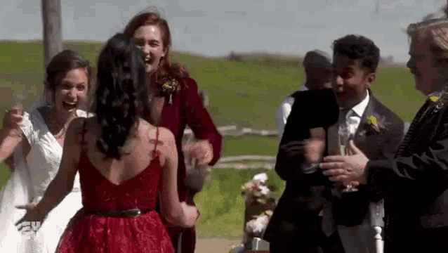 a group of people are standing next to each other at a wedding .