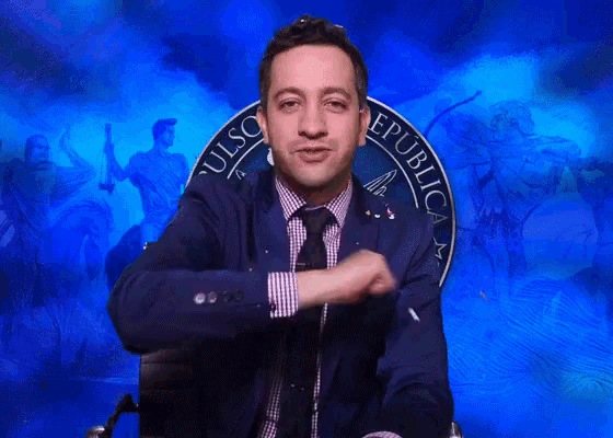 a man in a suit and tie is sitting in front of a blue sign that says republic