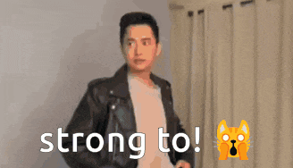 a man wearing a leather jacket is standing in front of a sign that says strong to