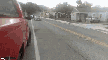 a red truck is parked on the side of the road next to a house