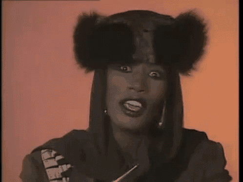 a woman is wearing a fur hat and a hooded jacket .