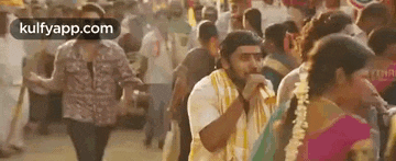 a man is standing in the middle of a crowd of people in a crowded street .
