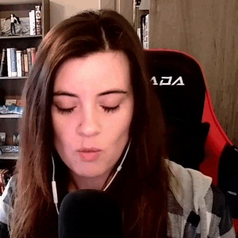 a woman is wearing headphones and sitting in a red and black chair that says ada on it