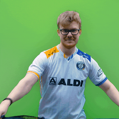 a man wearing glasses holds up a blue and white surfboard with the letter y on it