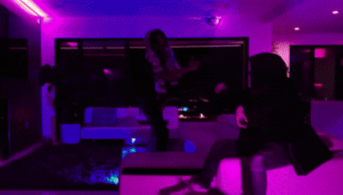 a blurry photo of two people dancing in a room with purple lights