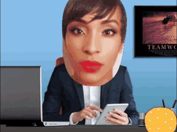 a woman is sitting at a desk with a poster on the wall that says teamwc