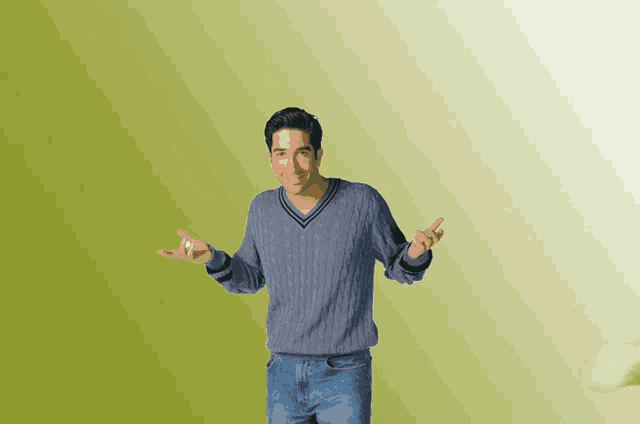 a man in a blue sweater is standing with his arms outstretched in front of a green background