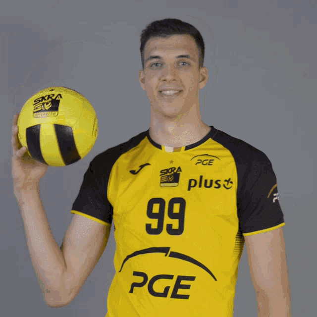 a man in a yellow shirt with the number 99 on it holds a yellow ball