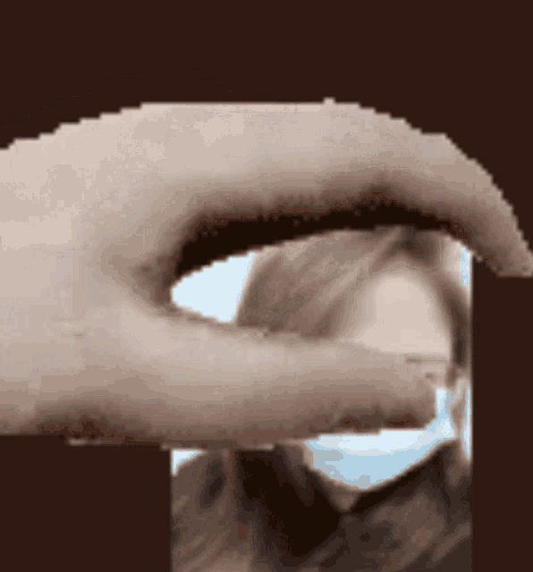 a pixelated image of a hand reaching out towards a woman wearing a face mask
