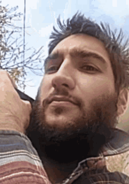 a man with a beard wearing a plaid shirt