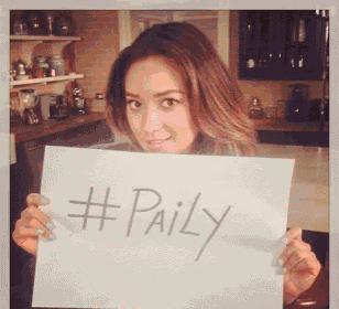 a woman holds a sign that says #paily