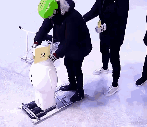 a person wearing a green helmet holds a yellow sign that says 2