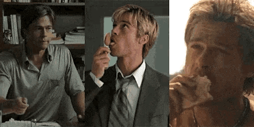 a man in a suit and tie is eating a piece of bread .