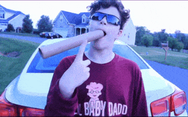 a boy wearing sunglasses and a shirt that says baby daddy on it