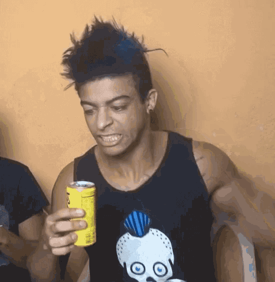a young man with a mohawk is holding a can of soda .