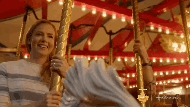 a woman is riding on a merry go round at a carnival .