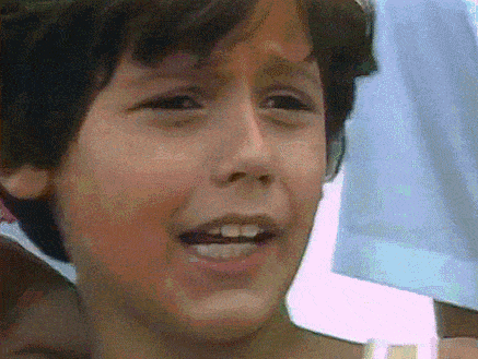 a close up of a young boy 's face with his mouth wide open