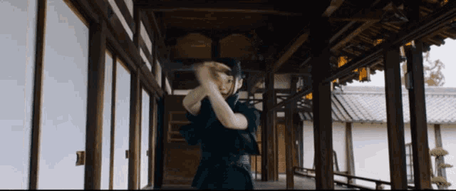 a man in a black robe is standing in a hallway holding a sword