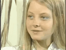 a close up of a woman 's face with long hair and blue eyes .