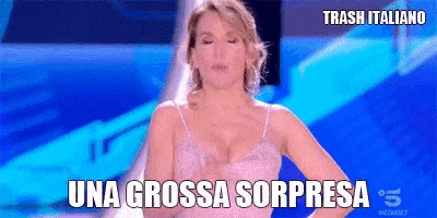 a woman in a white bra stands in front of a blue background with the words una grossa sorpresa above her