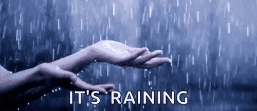a person 's hands are reaching out to catch a drop of rain .