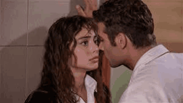 a man and a woman are kissing each other on the cheek .