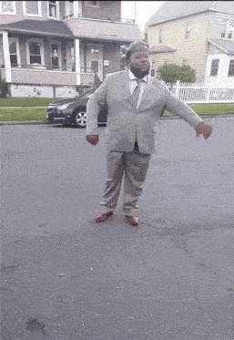 a man in a suit and tie is standing on the side of the road