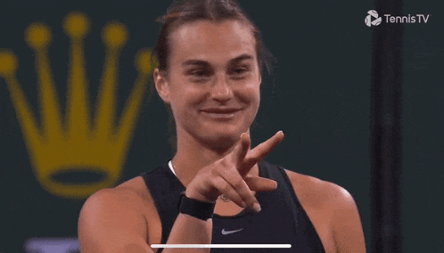 a tennis player named sabalenka is smiling and pointing at the camera