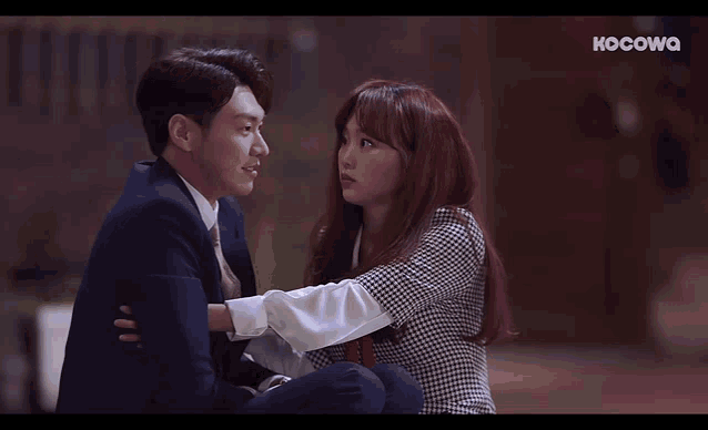 a man and a woman are looking at each other and the screen says kocowq