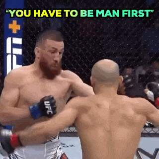 two men are fighting in a boxing ring and the words `` you have to be man first '' are written above them .