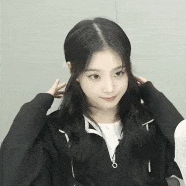 a girl with long black hair wearing a black hoodie
