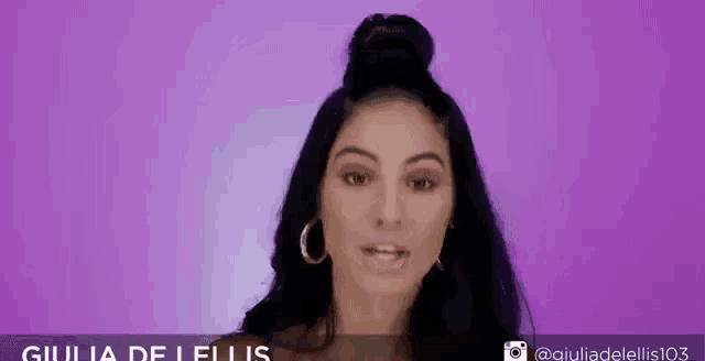 a woman with a bun and hoop earrings is making a funny face .