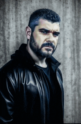 a man with a beard wearing a black jacket