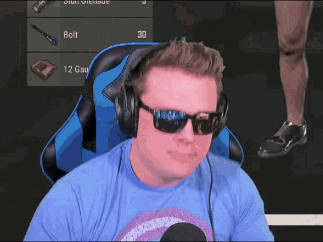 a man wearing sunglasses and headphones sits in front of a screen that says bolt on it
