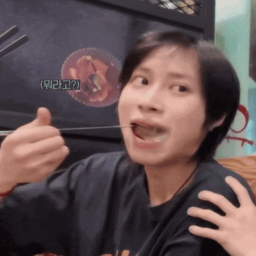 a person eating something with chopsticks with a foreign language on the bottom