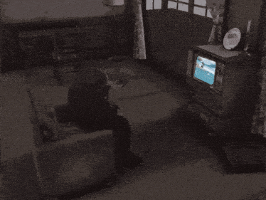 a black and white photo of a man playing a video game on a tv