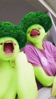 a person wearing a purple shirt and a broccoli head costume