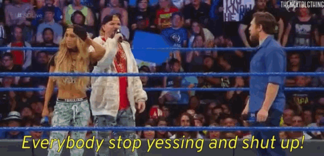a group of people standing in a wrestling ring with the words " everybody stop yssing and shut up " on the bottom