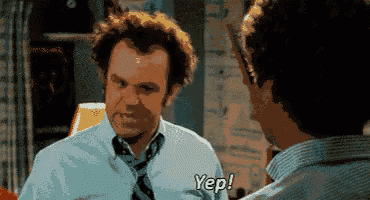 a man in a white shirt and tie is talking to another man and says yep