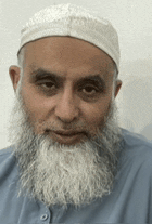 a man with a beard and a hat is wearing a blue shirt and a white hat .