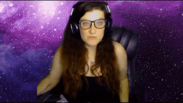 a woman wearing headphones and glasses is sitting in a chair in front of a purple background .