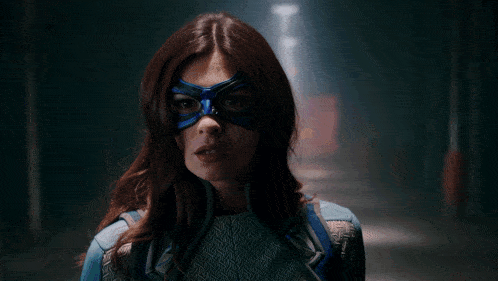 a woman wearing a mask with glowing blue eyes