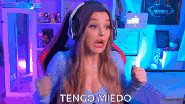a woman wearing headphones is sitting in a gaming chair in a room .